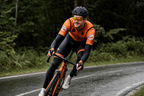 Cyclist cornering on a wet forest road in the rain wearing camera glasses
